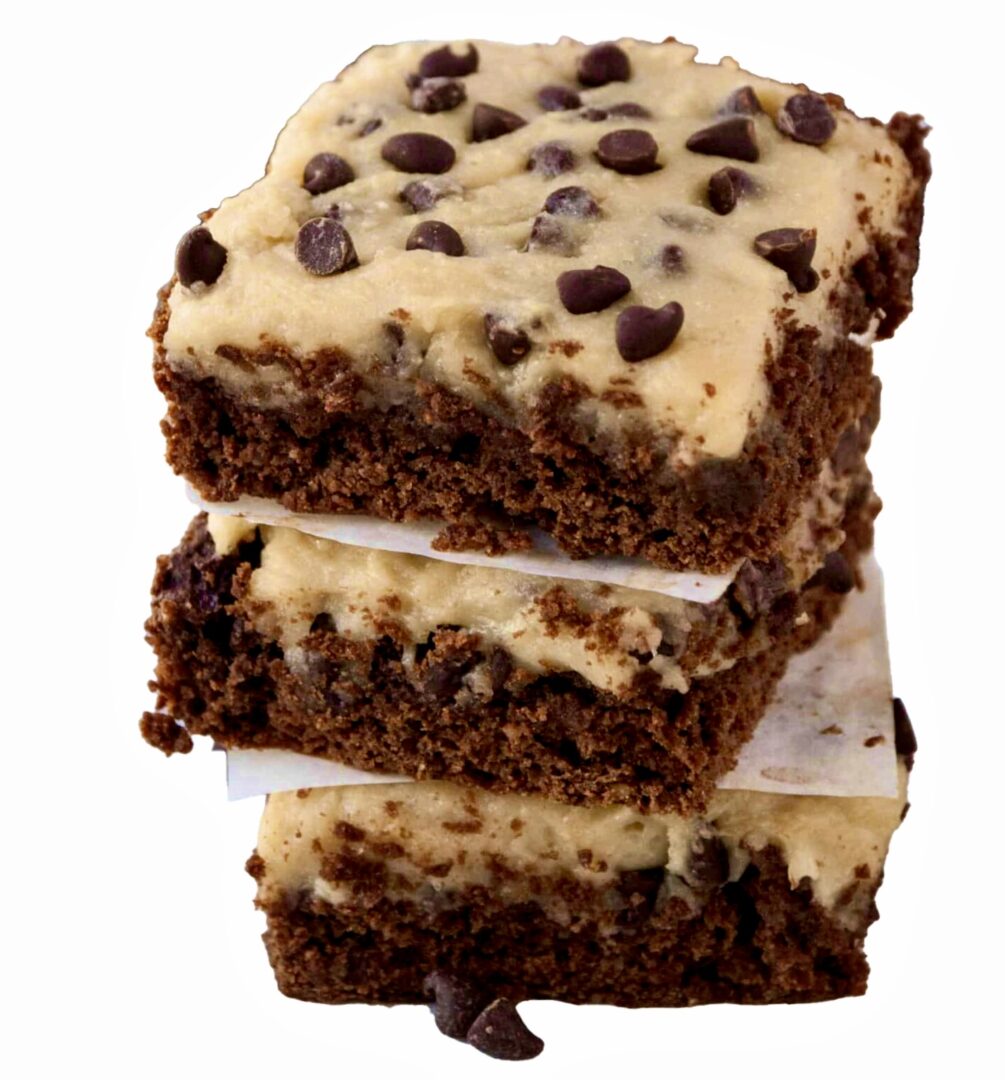 A stack of three chocolate chip brownies with white frosting.