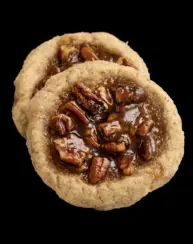 A close up of two cookies with nuts