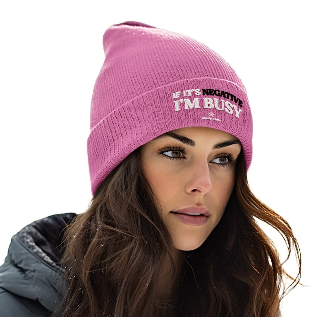 A woman wearing a pink beanie with the words " it's monday i 'm busy ".
