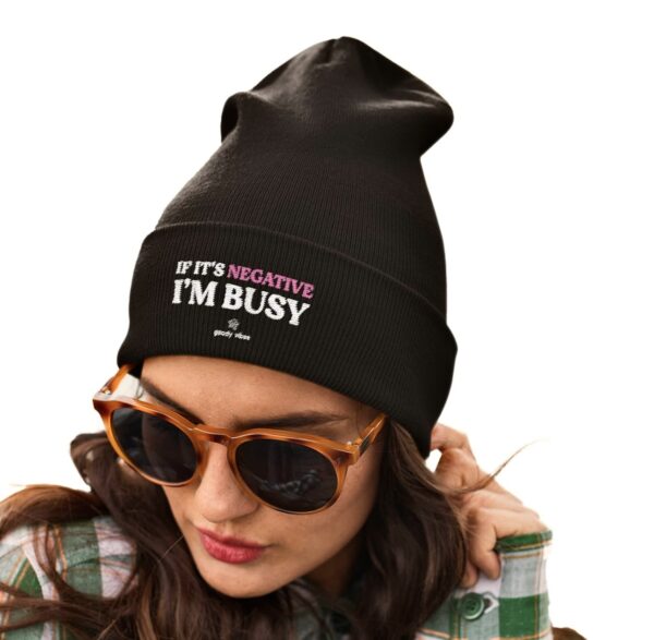A woman wearing sunglasses and a black beanie.