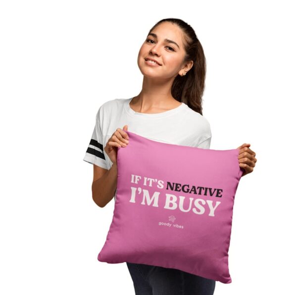A woman holding up a pillow with the words if it's negative i 'm busy on it.