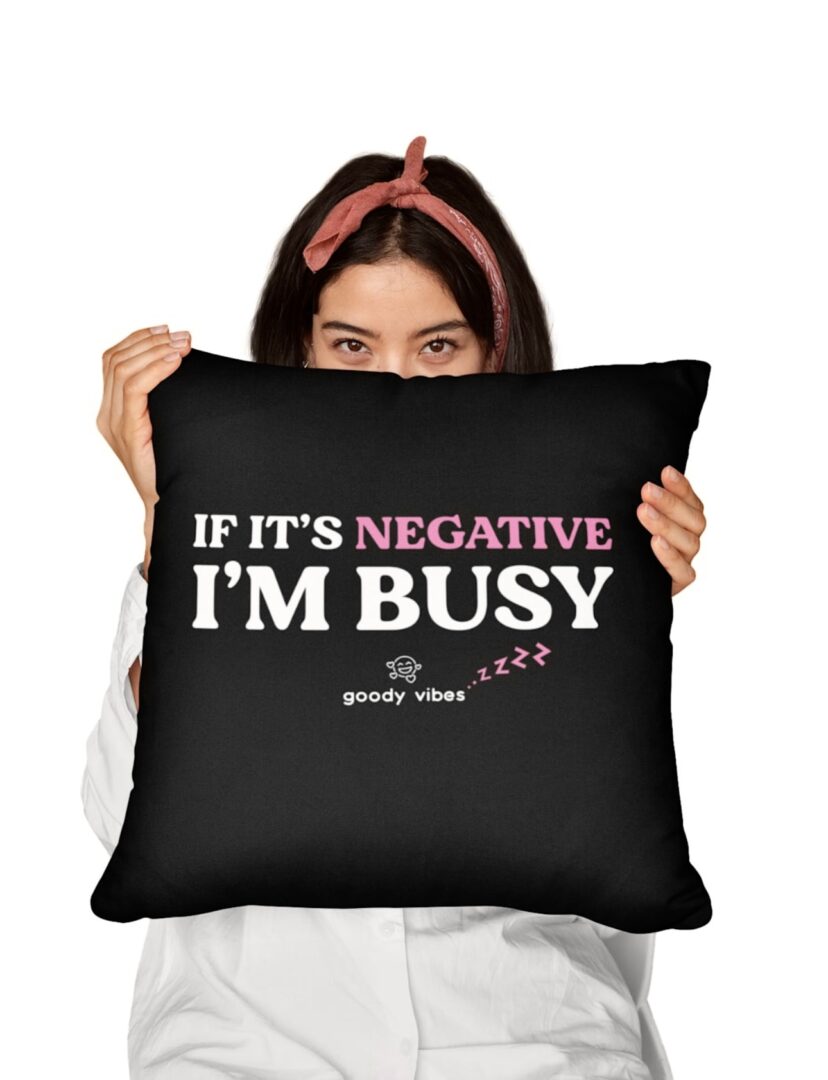 A woman holding a pillow with the words if it's negative i 'm busy.