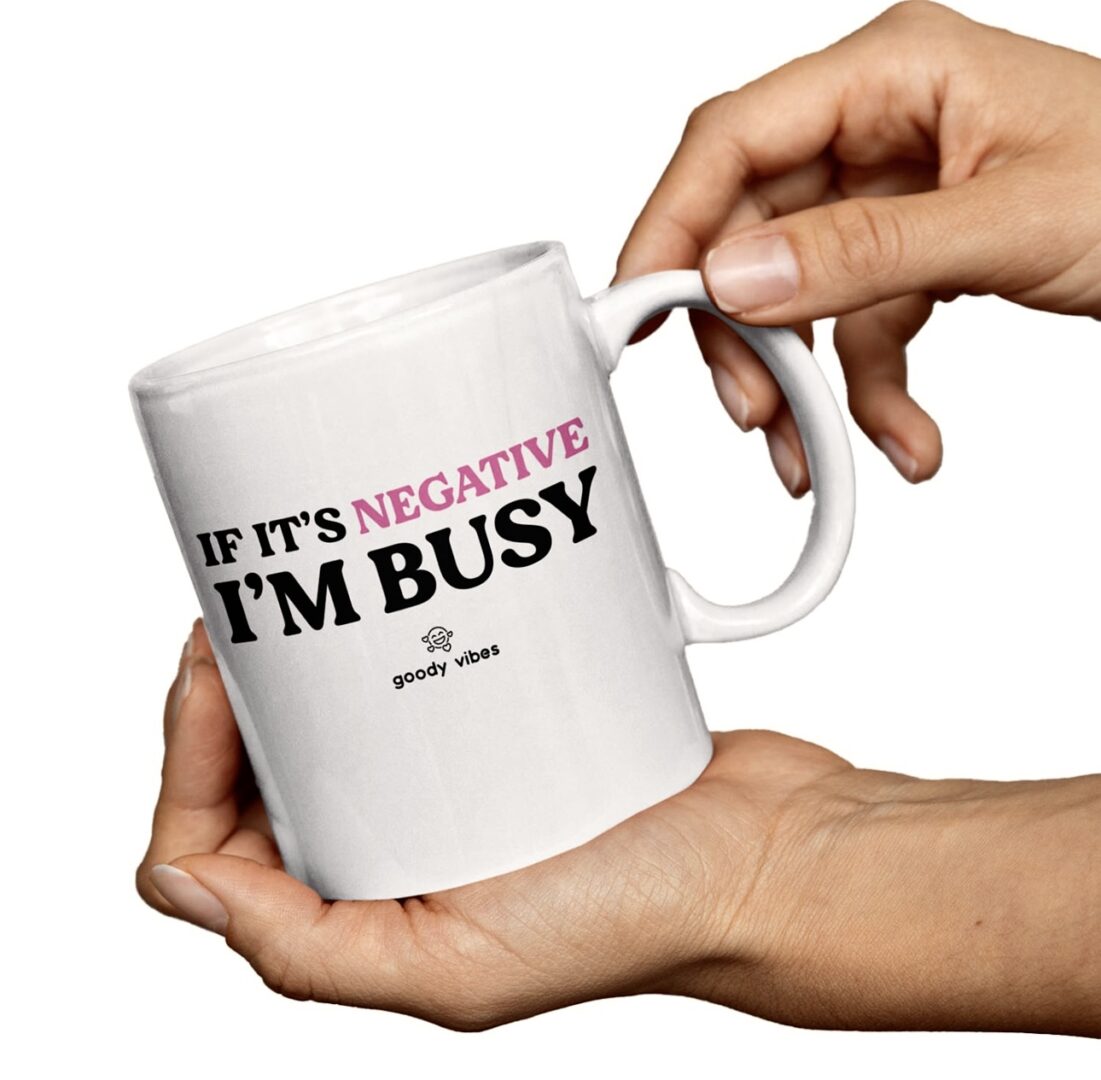 A person holding a coffee mug with the words if it's negative i 'm busy on it.