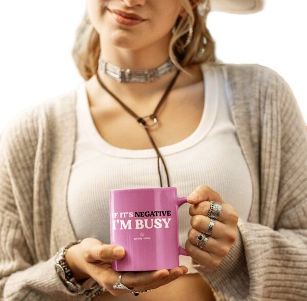 A woman holding a pink mug with the words " i 'm busy ".